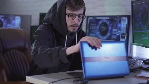 Confident Thoughtful Young Hacker Closing Laptop and Sighing. Portrait of Worried Caucasian Man in