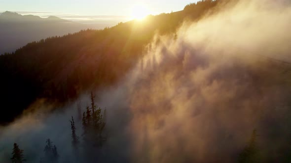 Aerial Drone Shot of Sunset in the Mountains Rays of Sun Break Through the Fog