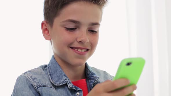 Happy Smiling Boy with Smartphone at Home