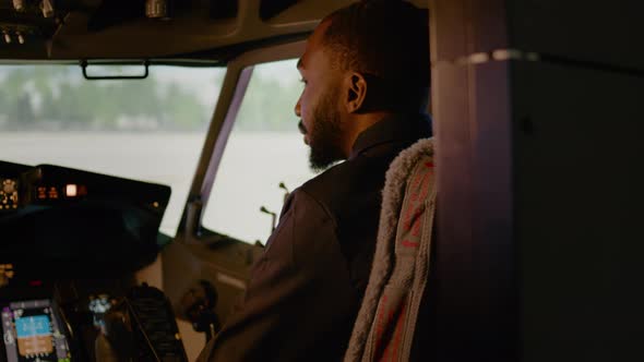 Portrait of African American Copilot Sitting in Airplane Cockpit