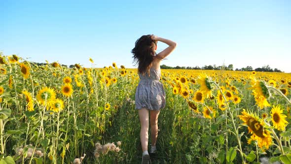 Close Up of Pretty Girl Running Through Field with Blooming Sunflowers
