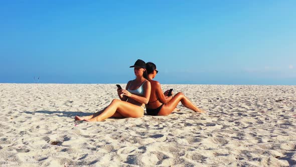 Female models relaxing on tranquil resort beach time by blue sea and white sand background of Koh Ph