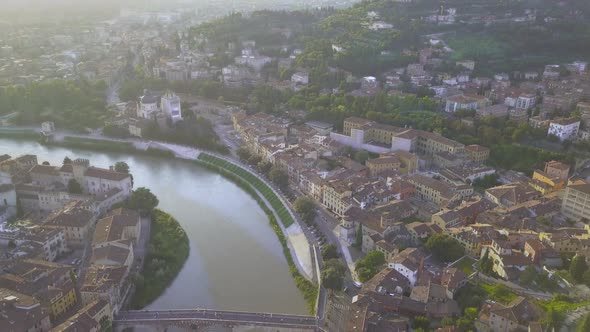 Aerial view of Verona City with bridges across Adige river. Medieval buildings with red tiled roofs