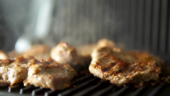 Grilled pork steak slices. juicy beef steak cooked on the grill. Cooking food in slow motion