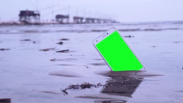 Smartphone with Green Screen on the Beach
