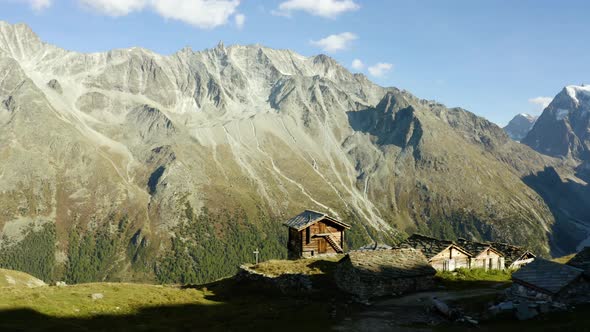 Flying behind small "alpage" chalets with high mountain peaks in the backgroundAutumn colors in Aro