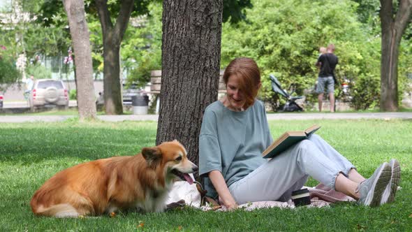 Woman Reading In A Park With Her Corgi Dog 5
