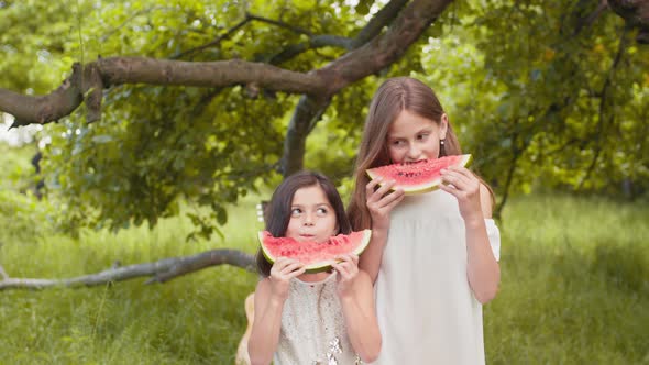 Pretty Kids in Summer Dress Enjoying Sweet Watermelon Outdoors