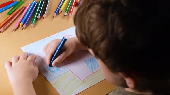 Child Coloring with Blue Pen