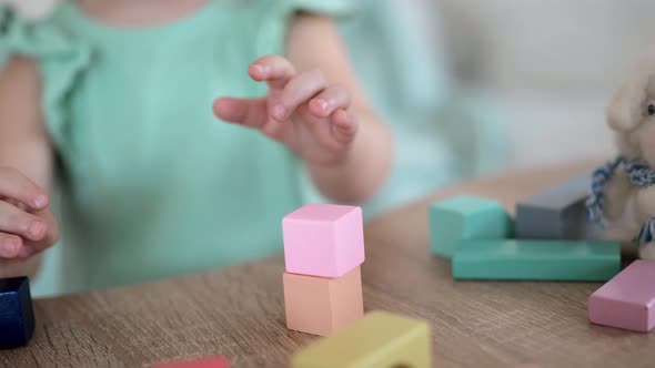 Adorable Little Girl Playing with Colorful Wooden Cubes