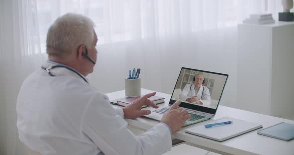 Chief Medical Officer of Hospital Is Communicating with Therapist By Video Call on Laptop, Giving