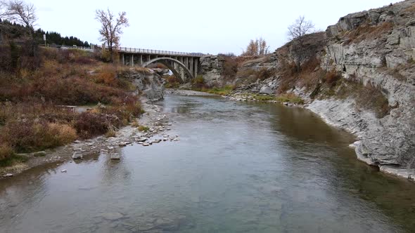 Slow motion aerial shot approaching an old arch bridge near Lundbreck falls in southern Alberta, Can