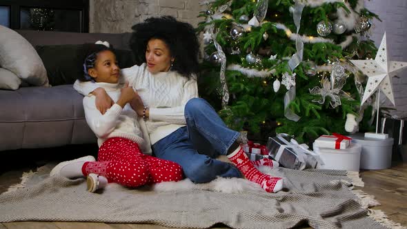 Portrait of African American Mom and Her Little Daughter Hugging and Talking Cute