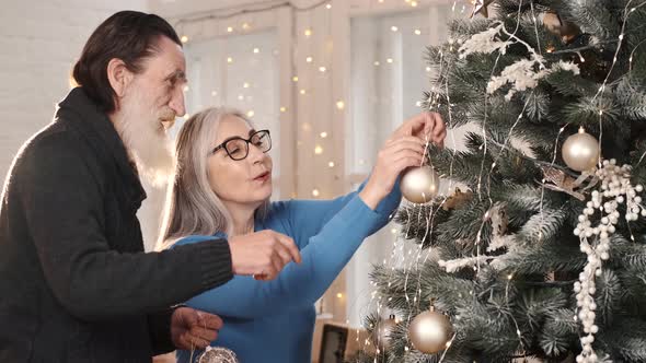 Senior Couple Decorate Christmas Tree Together at Home