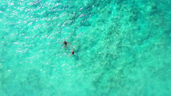 Tow young people swimming and having fun  in turquoise and crystal clear sea in Philippines