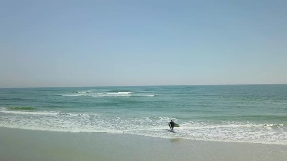 Drone flight over surfer at a beach in Florida.