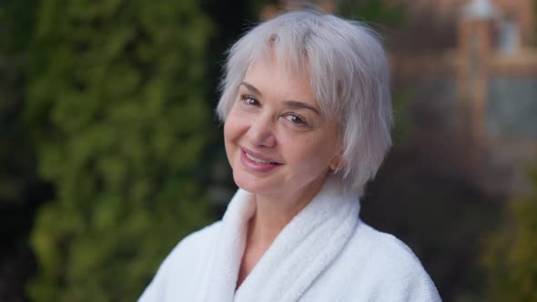 Closeup Portrait Happy Caucasian Mature Woman Looking at Camera Smiling Standing on Backyard