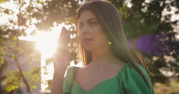 Beautiful Woman Say Hello Into the Phone at Summer Day