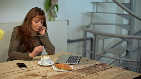 Woman Driking Coffee and Working in Coffeeshop