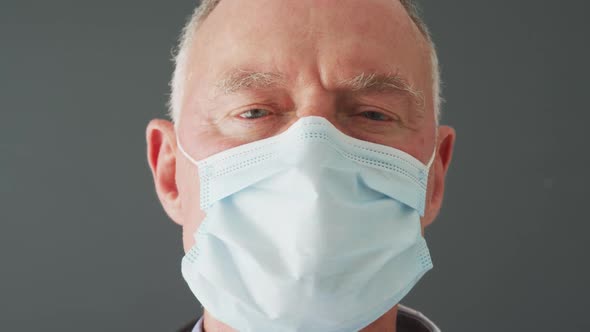 Close up of portrait of caucasian senior male doctor wearing face mask