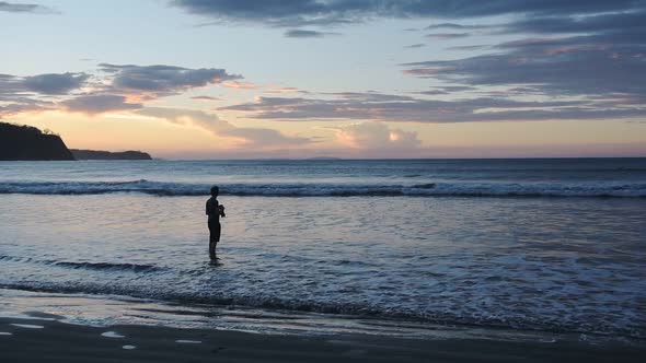 Silhouette Of A Male Photographer Capturing The Beautiful Sunset Scenery By The Sea Shore In Costa R