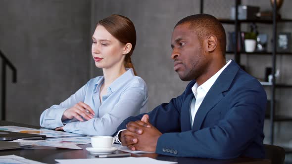 Office meeting: colleagues listening tto a corporate leader talking about a project