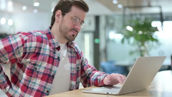 Hardworking Male Designer with Laptop Having Back Pain