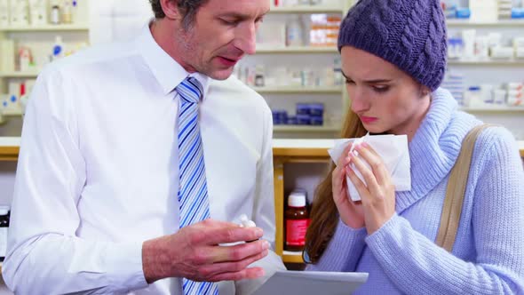 Pharmacist showing medicine to customer