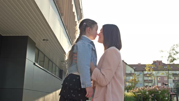 Young Woman Lovingly Hugs a Girl with Pigtails 67 Years Old