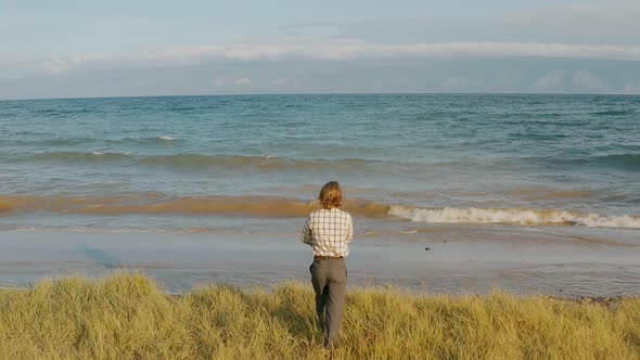 Man is walking along the lakeside Summer Baikal lake Olkhon island