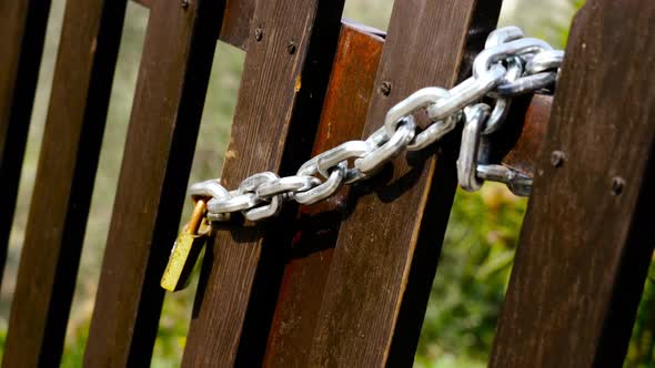 Brown Wooden Fence with Metal Chain and Yellow Padlock