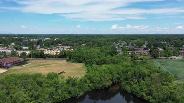 A high angle shot as the drone camera dolly in slowly over a pond's edge. It's a beautiful day with