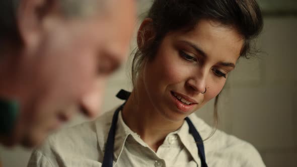 Senior Man Teaching Woman in Workshop