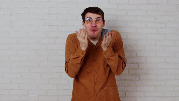 Young Man in Glasses on White Brick Wall