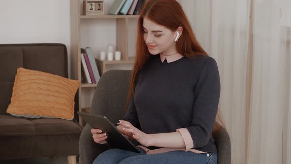 Smiling woman listening to music with tablet and headphones