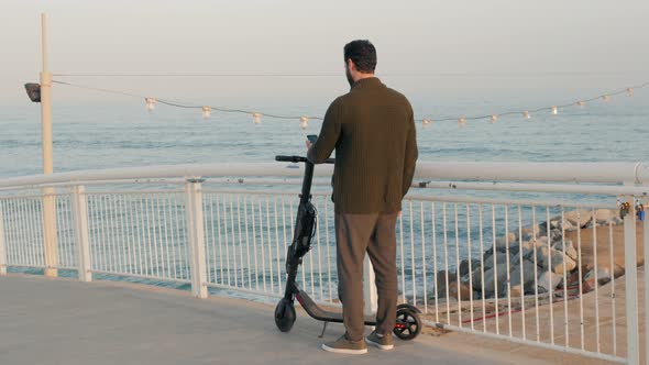 Tourist Man Take Electric Kick Scooter or Bike Bicycle in Sharing Parking Lot Tourist Phone