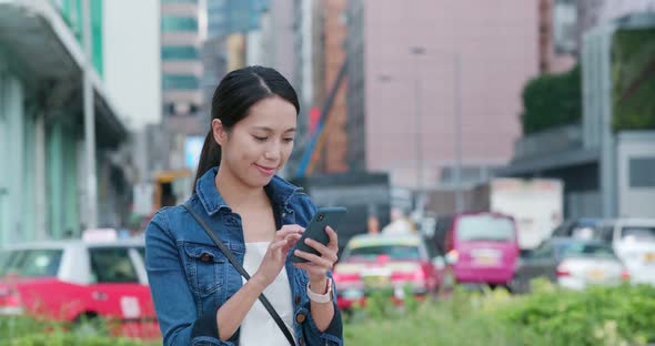 Woman search on mobile phone in the street