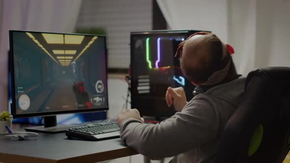 Competitive Gamer Streatching Hands Sitting on Gaming Chair