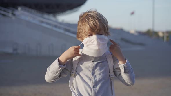 Caucasian Schoolboy Putting on Face Mask