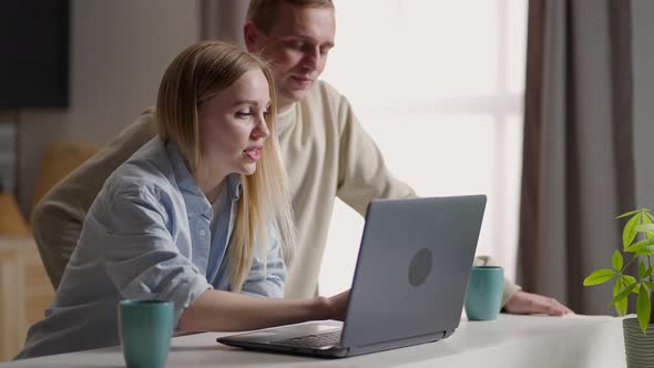 Couple 30s Wife and Husband in Kitchen Using Laptop Enjoy Eshopping Remotely Planning Future