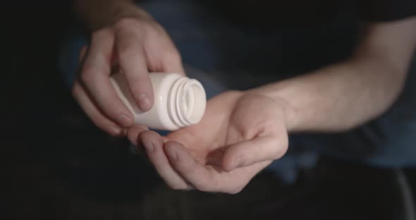 Man with Pills Sitting on the Floor