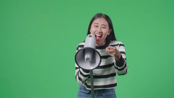 Asian Woman Shouting On Megaphone In The Green Screen Studio