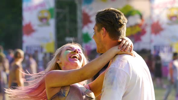 Cheerful Blonde Waving Hair, Hugging Smiling Handsome Man, Dancing at Festival