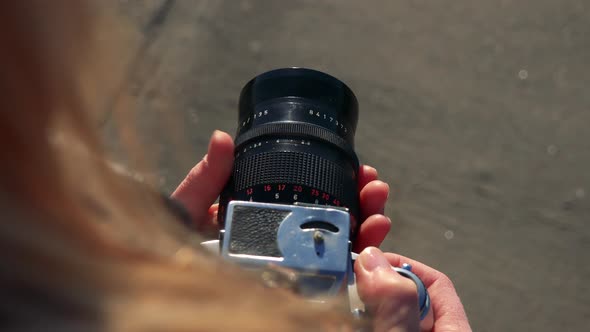 A Woman Uses Zoom on a Camera - Closeup Form Above