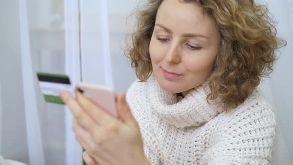 Woman Holding Credit Card And Using Smart Phone. Online Shopping Concept.