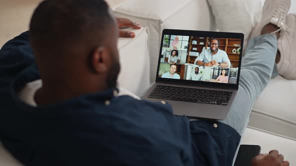AfricanAmerican Guy Making Video Call Greeting Staying at Home Back View