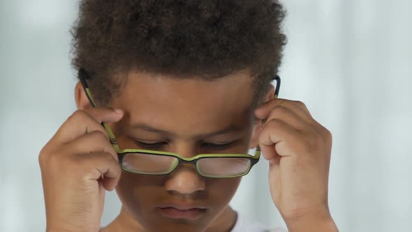 Little Boy Putting on Glasses Reluctantly and Taking Off, Sad Expression, Stress