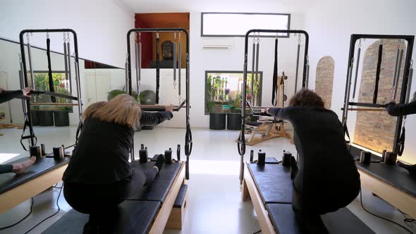 Women doing exercises on pilates reformer during training
