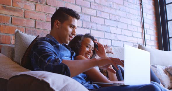 Couple Using Laptop on Sofa at Home 