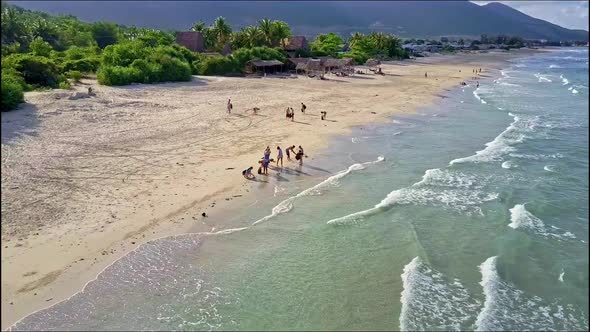 Aerial View People Walk on Edge of Ocean Sand Beach